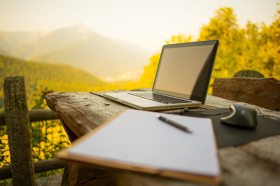 News - View of Laptop and Notebook on Wooden Table Outside