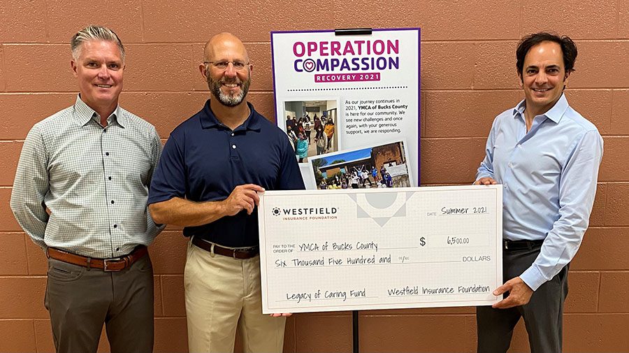 News - Community - GMG Holding a Donation Check For YMCA