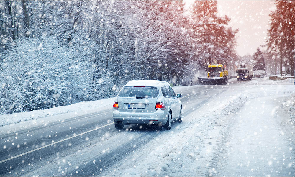 Blog - Car Driving in the Snow Storm with a Snow Plow Coming Down the Opposite Side of the Road