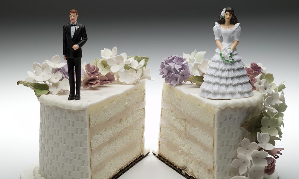 Blog - A Wedding Cake Cut in Half with the Husband Topper on the One Side and the Bride Topper on the Other