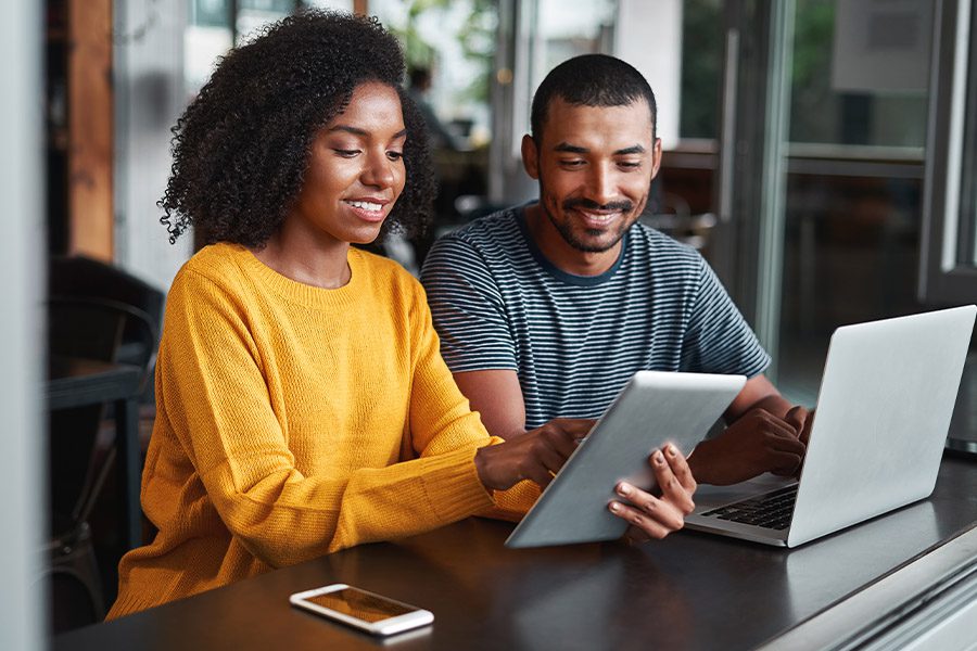 GMG Advantage - Couple Looking over Information on a Tablet and Laptop Before Making a Decision